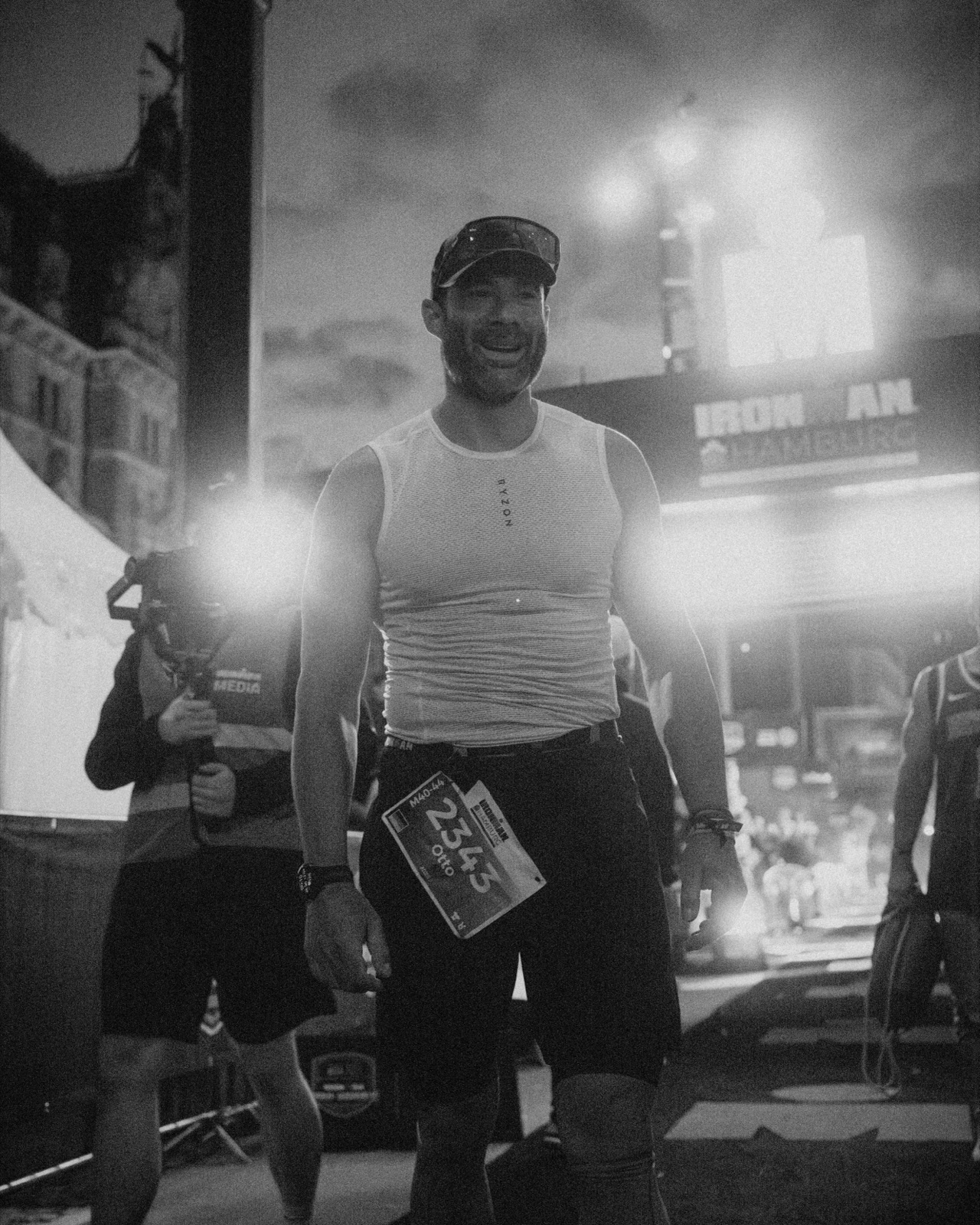 Otto beim nächtlichen Zieleinlauf des IRONMAN Hamburg, Schwarz-Weiß-Aufnahme, Startnummer 23343